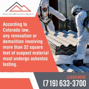 Two restoration workers in white hazmat suits are handling suspected asbestos roofing materials.